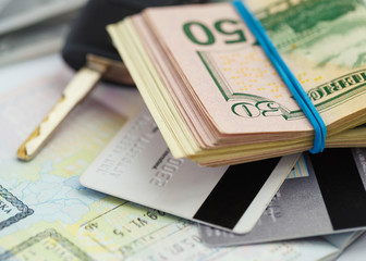 American money, credit cards and car key lies on thr top of the