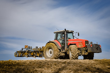 Obraz premium Ackerschlepper mit Grubber bei der Bodenbearbeitung
