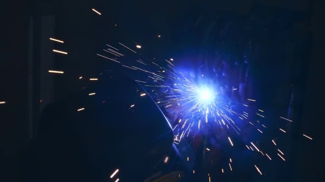 Welding works on a black background and a lot of sparks flying around. Slow motion, high speed camera, 250fps