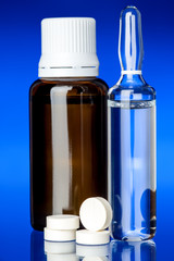 glass bottle cough syrup with a pill.