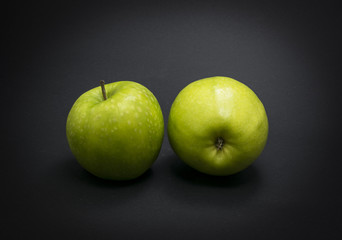 Green apples on black background.