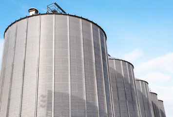 Agricultural silos on blue sky.