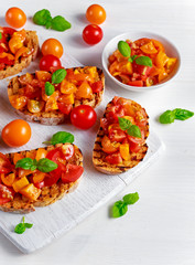 Tasty Traditional Tomato bruschetta with fresh basil on white board