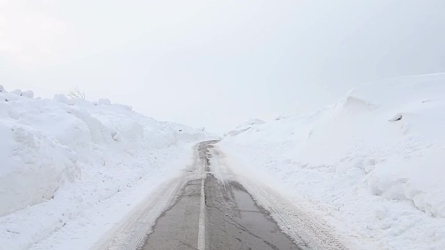 Walking on snowy road with snowdrifts in the cold winter, POV Steady cam shot, Personal perspective