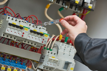 electrician examining current voltage with screwdriver tester