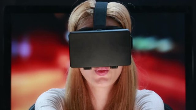 Car simulator using virtual reality technology. Girl with pleasure uses head-mounted display.