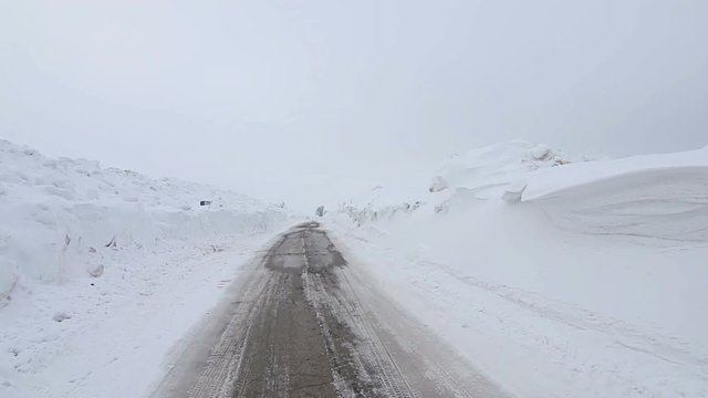 Walking on snowy road with snowdrifts in the cold winter, POV Steady cam shot, Personal perspective
