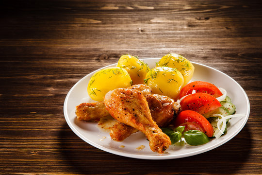 Grilled chicken legs with boiled potatoes and vegetable salad 