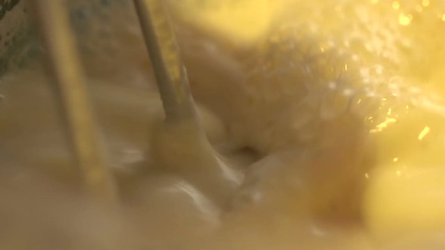 mixer whips egg whites in slow motion closeup