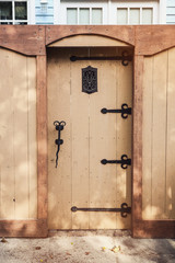 Wooden gate in the city with wrought iron hardware