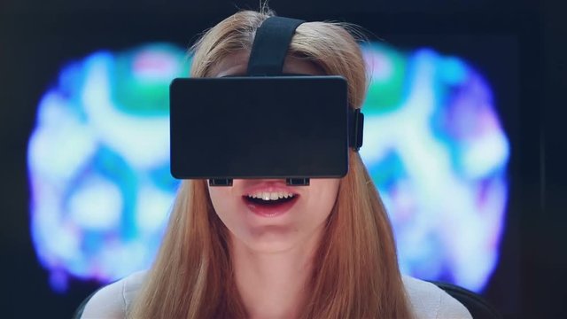 Virtual reality game. Girl with pleasure uses head-mounted display.