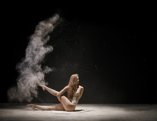 Obraz na płótnie Canvas Sporty blonde in beige body in cloud of dust