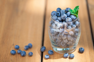 Blueberries in glass on wood