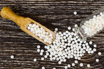 homeopathic scattered peas on the wooden background. The concept of alternative medicine