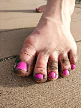 Painted toes with feet covered in some volcanic sand, in Tenerife Spain