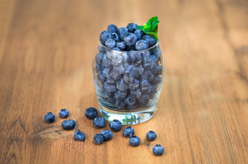 Blueberries in glass on wooden deck lightning