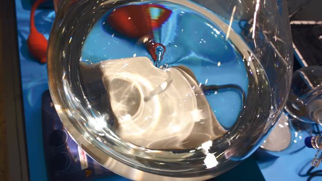 In the chemical laboratory glass flask with transparent liquid are mixed via magnetically stirred. Slow mo, slow motion, slo mo, high speed camera, 240fps, 250fps