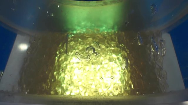 Air bubbles float up from the bottom which highlighted in yellow. Slow mo, slow motion, slo mo, high speed camera, 240fps, 250fps