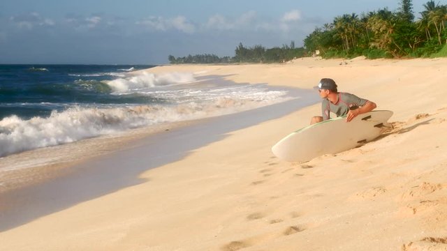 A Surfer Waxing Board Before Surfing Hawaii