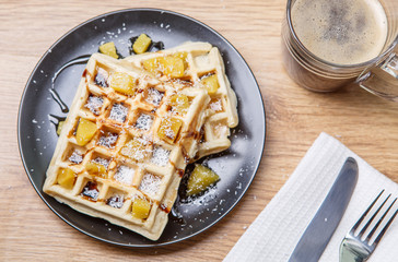 Black plate with homemade waffles, tangerines, chocolate