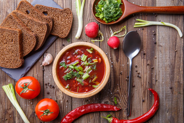 Beet soup in wooden plate with vegetables