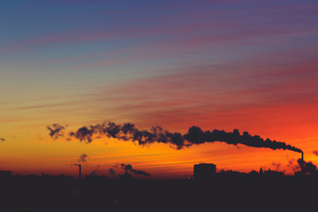 Silhouettes of modern buildings, architecture and smoke from the chimneys 