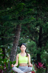 Beautiful young woman sitting in ardha Padmasana