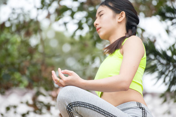 Beautiful young woman sitting in ardha Padmasana