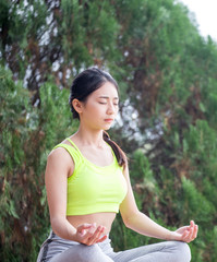 Beautiful young woman sitting in ardha Padmasana