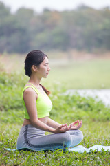 Beautiful young woman sitting in ardha Padmasana