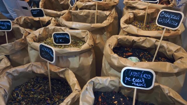 Large bags of black, green, fruit and other tea on the market. Shot in motion