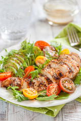 Healthy salad plate with colorful tomatoes, chicken breast and avocado