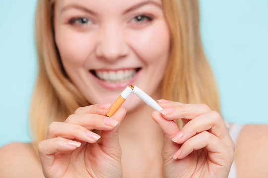 Smilling girl is breaking cigarette