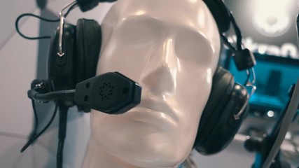 Black professional headphones with a microphone on a head of white mannequin in a store professional audio equipment. Shot in motion