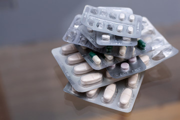 A pile of various pills in half used blister packagings