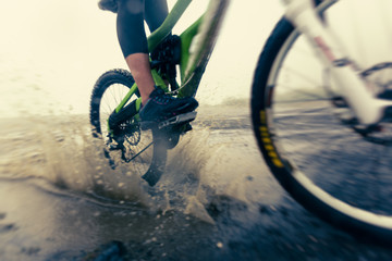 Mountain Biker Racing Through Puddle