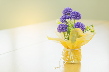 Beautiful colors of the flowers in the vase on a wooden table sweet.