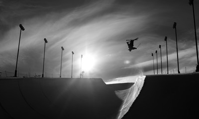 Skier doing an inverted trick in winter snow halfpipe
