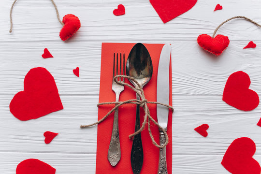 Valentine's Day.cutlery and felt heart on a wooden background 