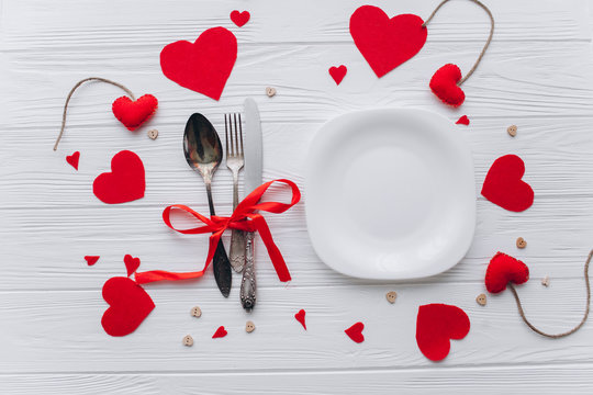 Valentine's Day. plate,cultery, heart felt and decor on wooden background