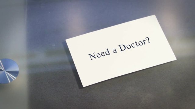 Hand puts business card on table with text Need a Doctor