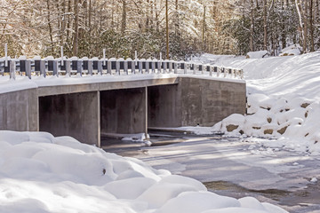 Concrete bridge is covered with snow.