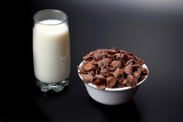 glass of milk and a plate of corn flakes.