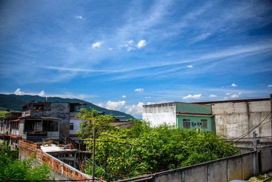 View of houses, mountains and building of brick slums in Bangu neighborhood, where the prison, the Penitentiary Complex of Gericino and Bangu dump are located, the West Zone of Rio de Janeiro, Brazil