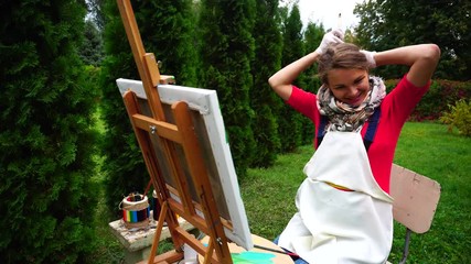 Women Beautiful Painter Before Drawing Tying Hair in Ponytail and Posing Into Camera Painted With Brushes and Palette, Stand in Park Outdoor.
