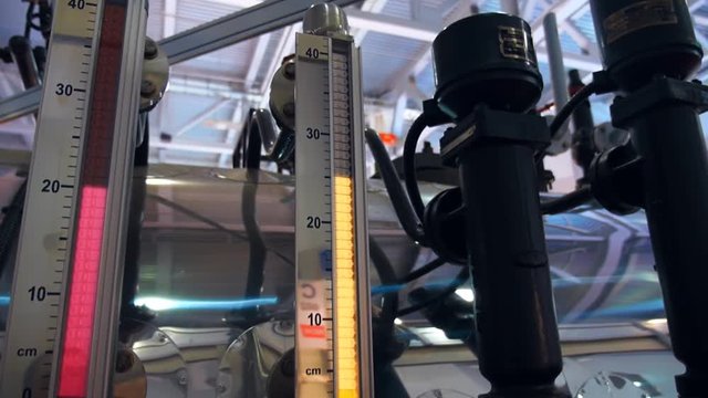 Industrial equipment with a plurality of pipes, valves and gauges the level of water in the boiler. Shot in motion