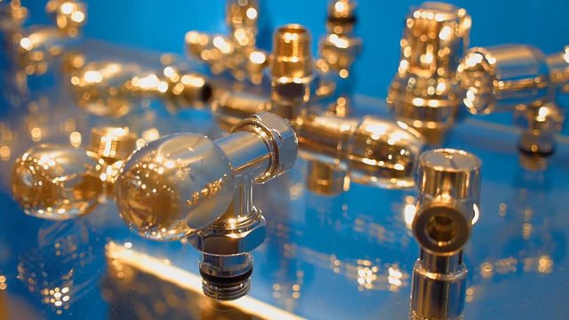 The rows of gilded parts of the water faucet on the shop showcase. Shot in motion