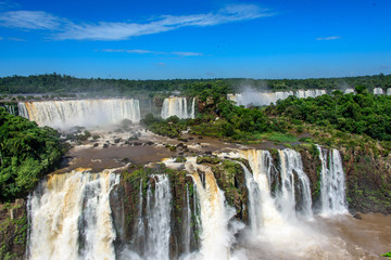 Aerial view of waterfalls cascade of Iguazu Falls with extensive tropical forest and powerful flows...