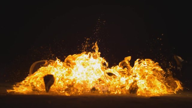 A candy skull molotov cocktail falls to the ground and explodes. Slow motion.