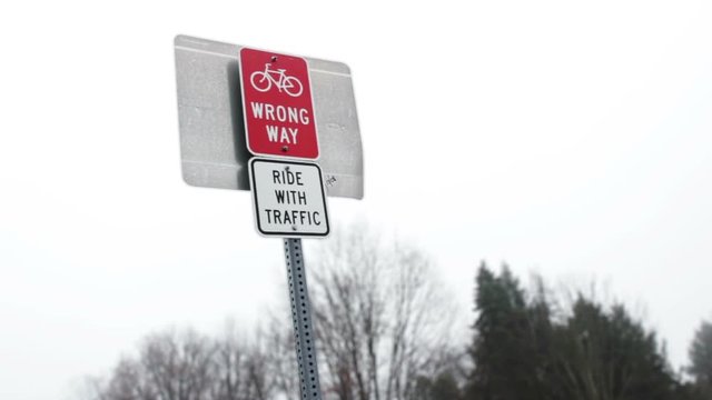 A Wrong Way Sign with a Ride with Traffic sign for Bike Trail